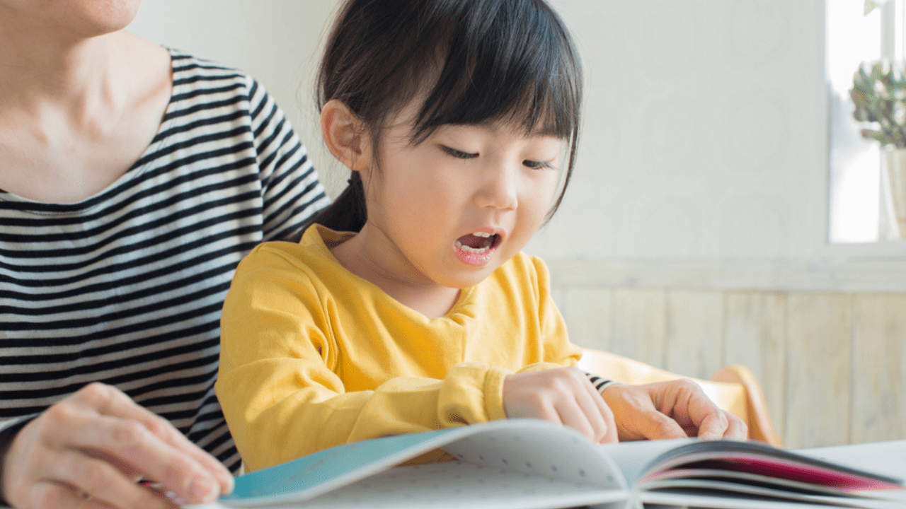 Child and parent reading book.