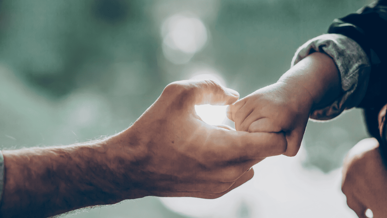 Elderly hand holding child's hand.