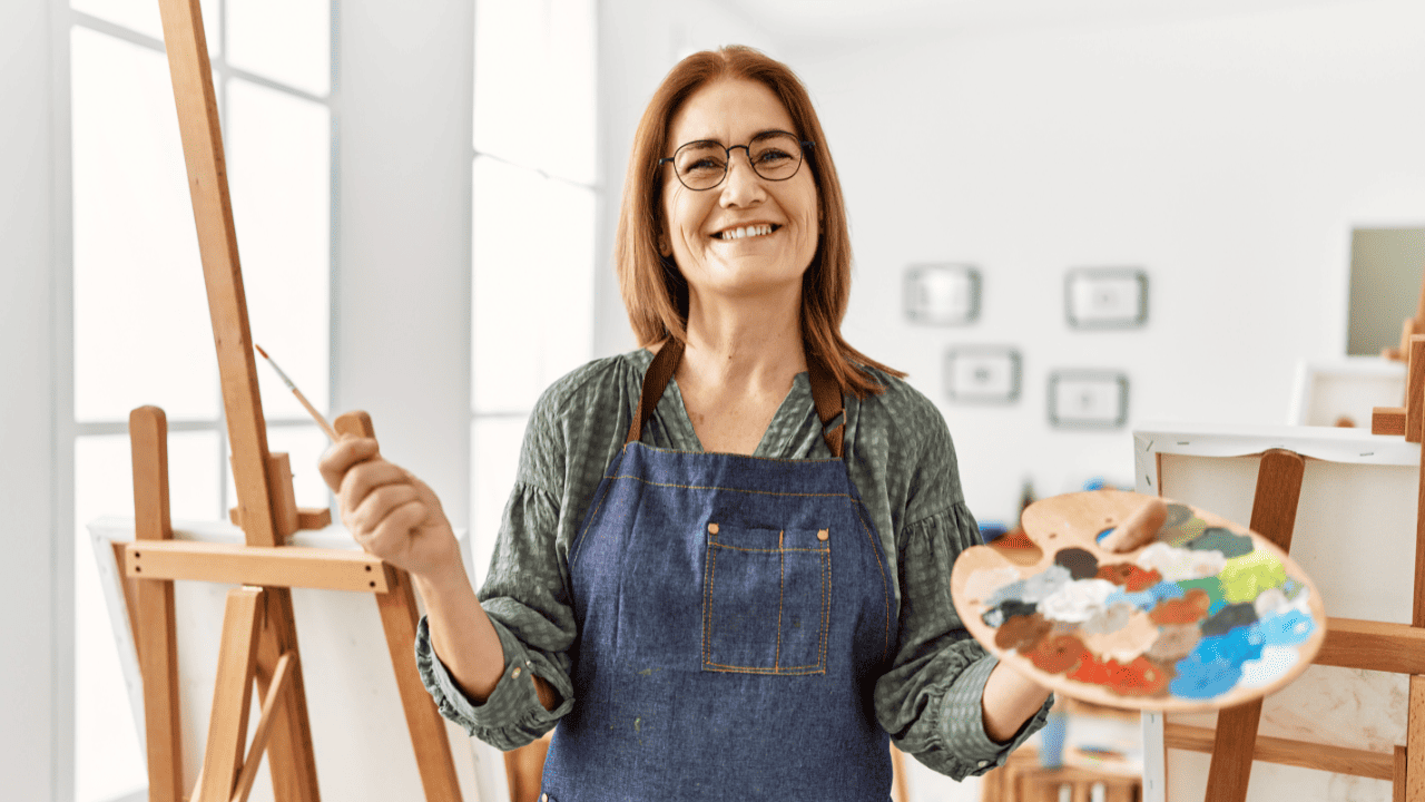 Woman painting with a brush and paint palette.