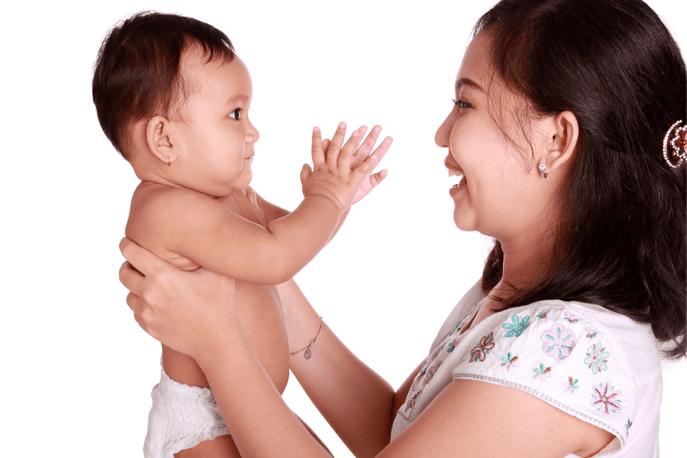 Mother in white shirt holding baby and interacting with her child. Observing parent child interaction course. 